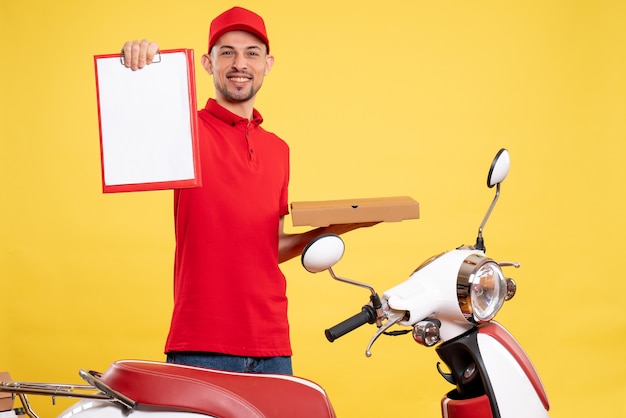 Mensajero masculino de vista frontal en uniforme rojo con caja de comida en el trabajo de servicio uniforme de trabajo de bicicleta de trabajador de entrega de color amarillo