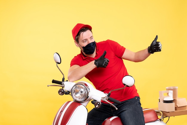 Foto gratuita mensajero masculino de vista frontal en uniforme rojo y máscara en amarillo