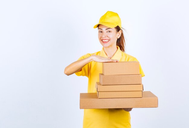 Mensajero mujer entregando un stock de cajas de cartón.