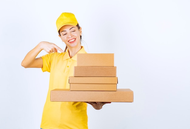 Mensajero mujer entregando un stock de cajas de cartón.