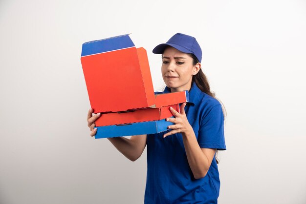 Mensajero mujer joven con cartón de pizza y portapapeles