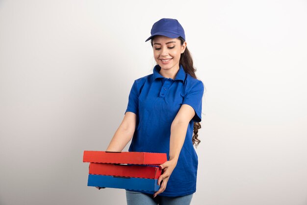 Mensajero mujer joven con cartón de pizza y portapapeles