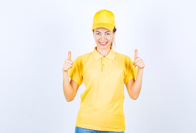 Mensajero mujer en uniforme amarillo mostrando signo de mano de disfrute.