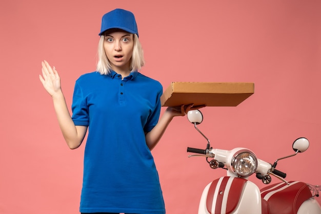 Mensajero mujer vista frontal con caja de pizza en el rosa