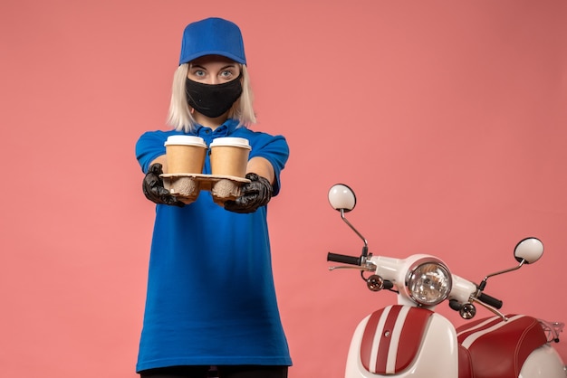 Foto gratuita mensajero mujer vista frontal sosteniendo tazas de café en la rosa