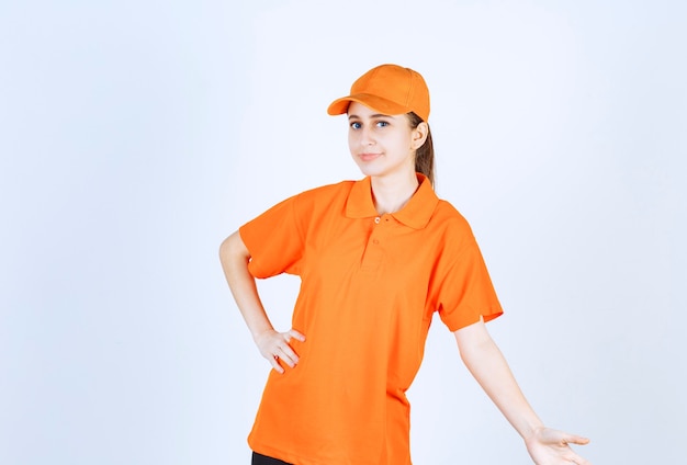 Foto gratuita mensajero mujer vistiendo uniforme naranja y gorra.