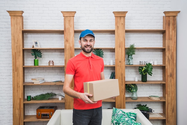 Foto gratuita mensajero con paquete en habitación elegante