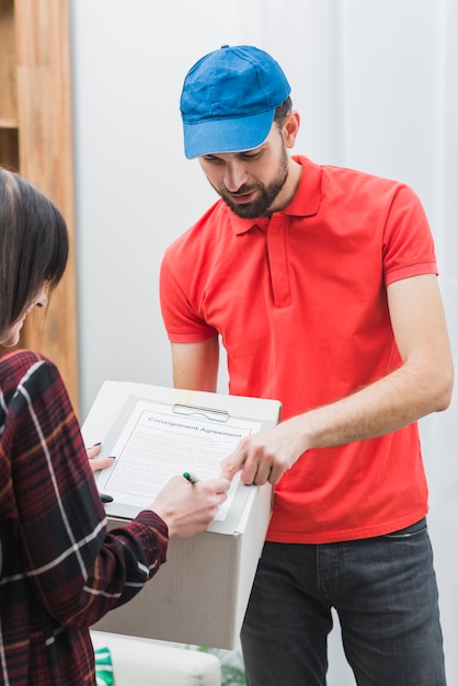 Mensajero que muestra el lugar del cliente para la firma