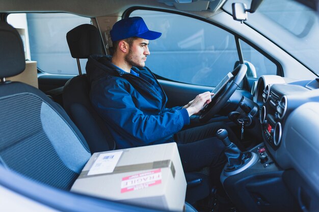 Mensajero que usa la tableta en el coche