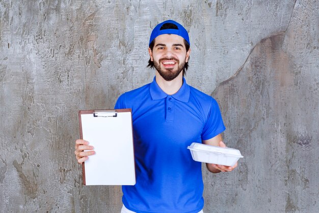 Mensajero con uniforme azul sosteniendo una caja de plástico para llevar y pidiendo una firma.