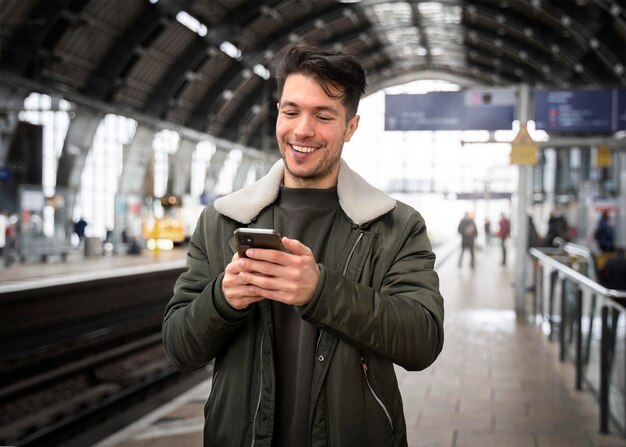 Mensajes de texto de hombre sonriente de tiro medio