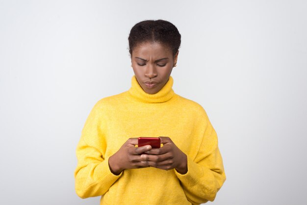 Mensajes de texto de mujer afroamericana seria en smartphone