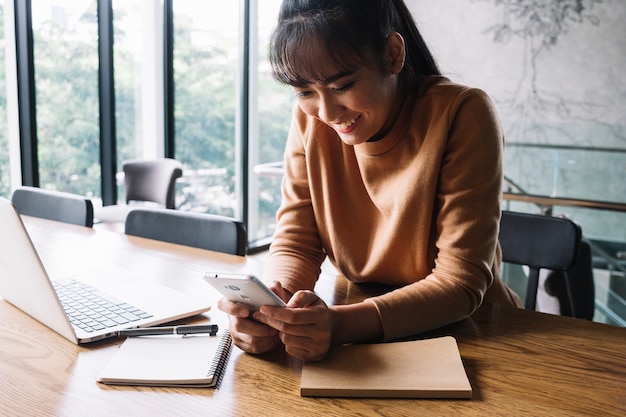 Foto gratuita mensajes de texto de la mujer en el teléfono