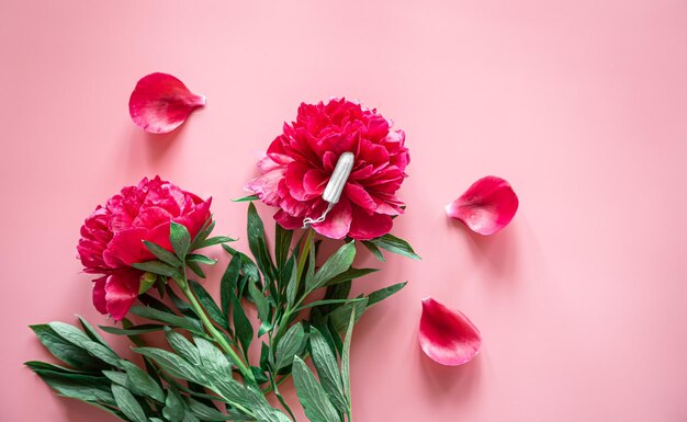 Menstruación plana de tampones y flores y concepto de salud de la mujer