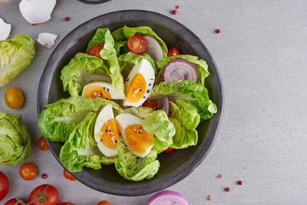 Menú de dieta. Ensalada saludable de verduras frescas, tomates, huevo, cebolla. Concepto de comida saludable.