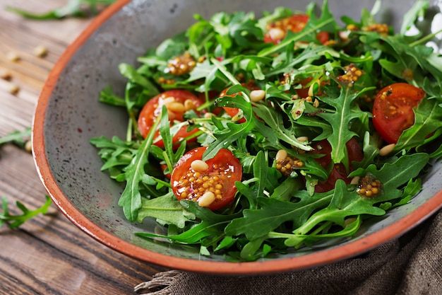 Menú dietético Cocina vegana. Ensalada saludable con rúcula, tomates y piñones.