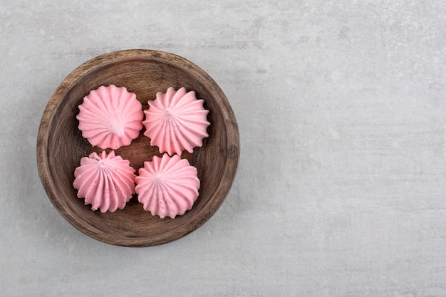 Merengue rosa sobre una tabla, sobre la mesa de mármol.