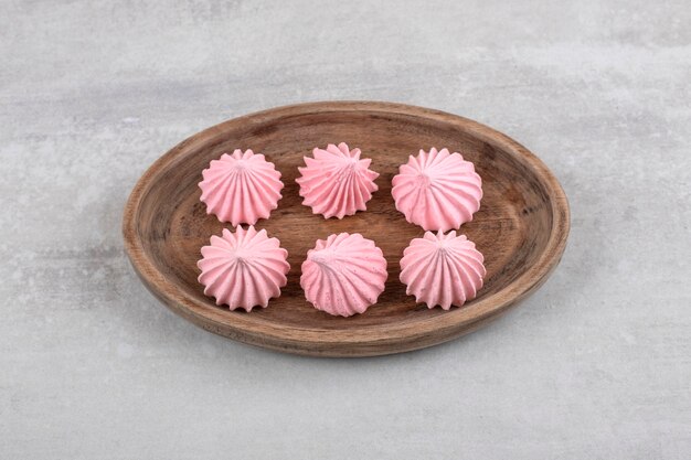 Merengue rosa sobre una tabla, sobre la mesa de mármol.