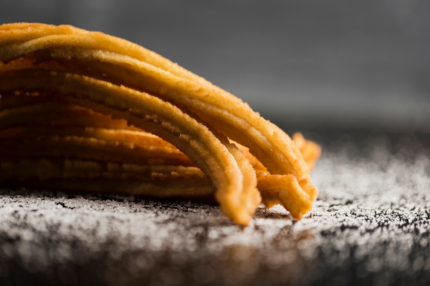 Merienda española de churros con vista frontal de azúcar