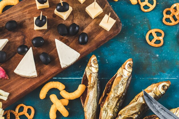 Merienda de pescado seco con queso, aceitunas y galletas saladas