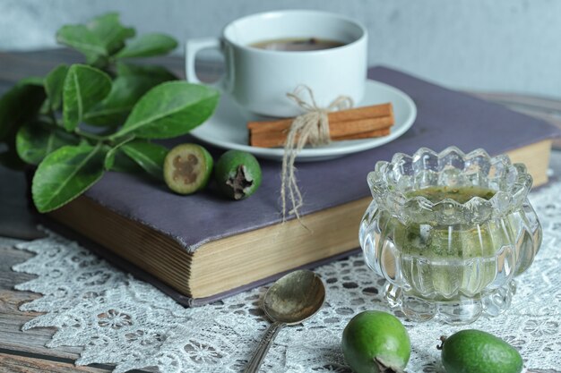 Mermelada de feijoa y taza de té en la mesa de madera.
