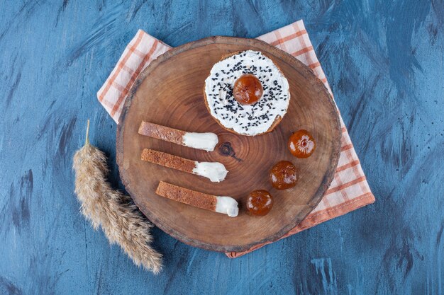 Mermelada de higo y pan de queso a bordo sobre un paño de cocina, sobre la mesa azul.