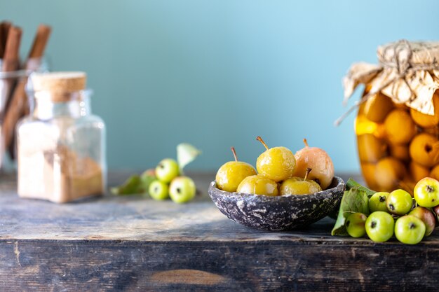 Mermelada de manzana del paraíso y manzanas del paraíso en jarabe de azúcar sobre una superficie de madera vieja