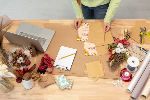 Mesa alta vista de flores y elementos de papelería