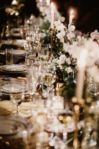 Mesa de boda con velas decoradas con ramos de flores.