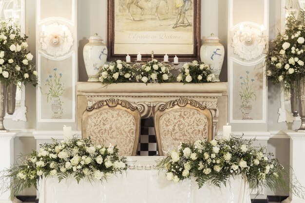 Una mesa para bodas con decoraciones florales y velas con bombillas colgantes