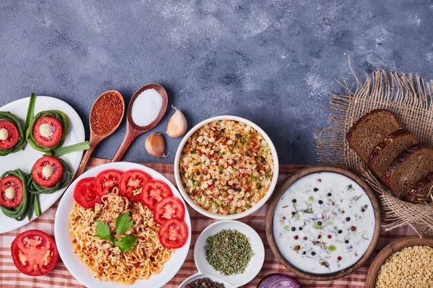 Mesa de comedor con alimentos mixtos en platos blancos.