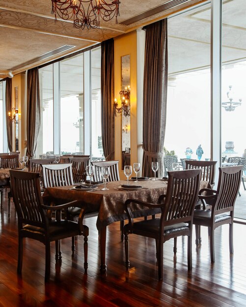 Mesa de comedor con sillas y vajilla.