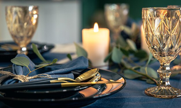 Mesa con copas de vino texturizadas, velas y hojas.