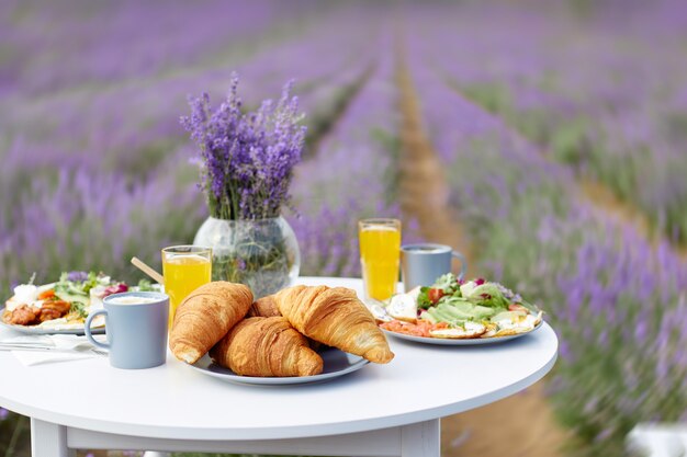 Mesa decorada con comida en campo lavanda