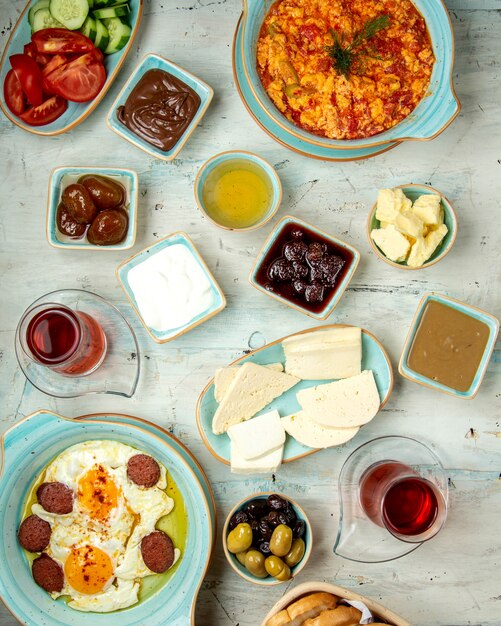 Mesa de desayuno de diferentes tipos de huevos fritos quesos miel chocolates y té