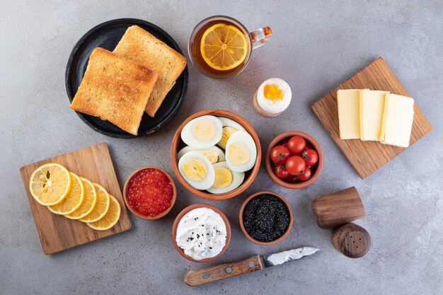 Mesa de desayuno con una taza de té y huevos duros en la mesa de piedra.