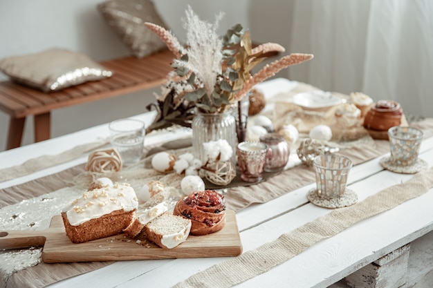 Mesa con elementos de decoración de Pascua y pasteles festivos. Composición hogareña acogedora.