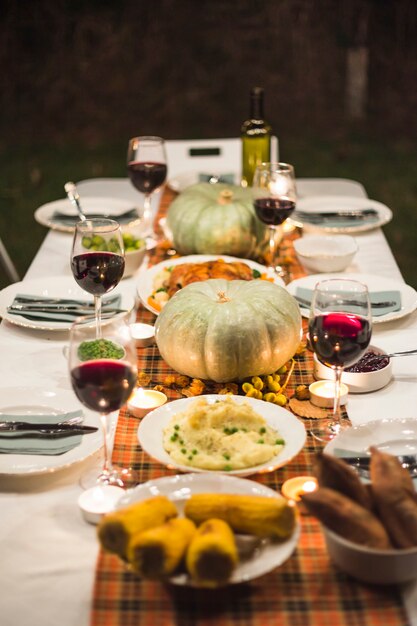 Mesa festiva con diferentes comidas y calabazas.