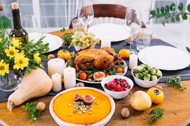 Mesa festiva con pollo al horno y verduras.