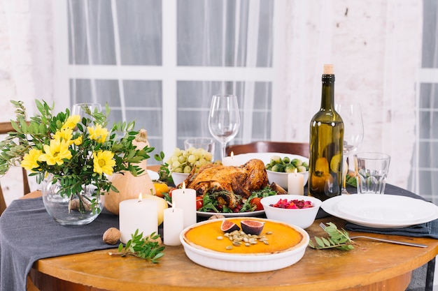 Mesa festiva con pollo al horno y vino.