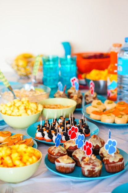 Mesa de fiesta decorada con diferentes postres y snacks.