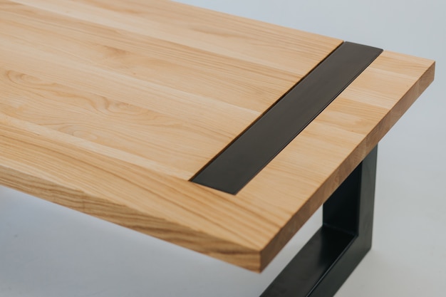 Mesa futurista hecha de una superficie de madera y metal negro.