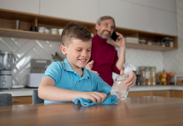 Foto gratuita mesa de limpieza de niño sonriente de tiro medio