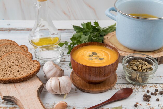 Mesa de madera de alta vista con sopa y rebanadas de pan