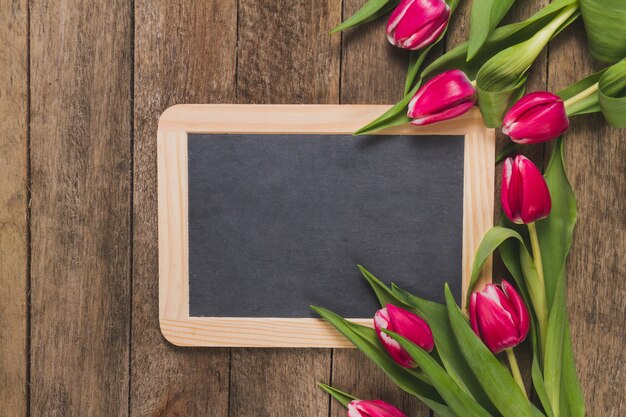 Mesa de madera con pizarra y tulipanes