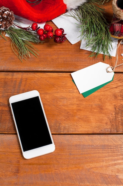 mesa de madera con teléfono y adornos navideños.