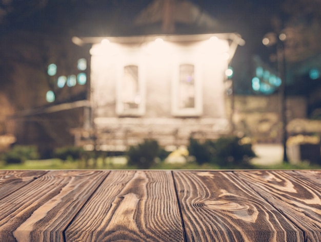 Mesa de madera vacía frente a telón de fondo casa borrosa