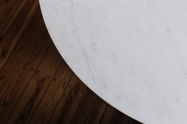 Mesa de mármol blanco y piso de madera.