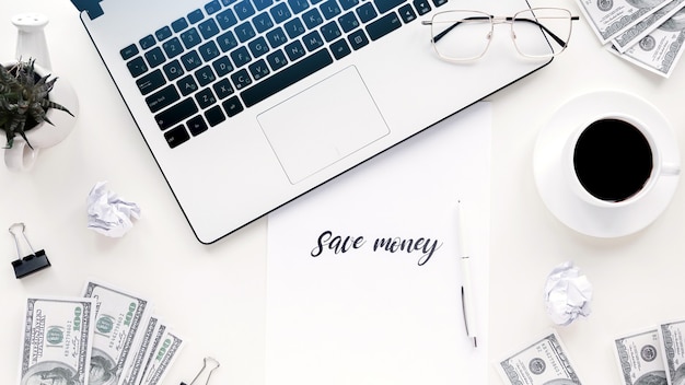 Foto gratuita mesa con material de trabajo de finanzas. ordenador portátil, dinero, café, bolígrafo, papeles