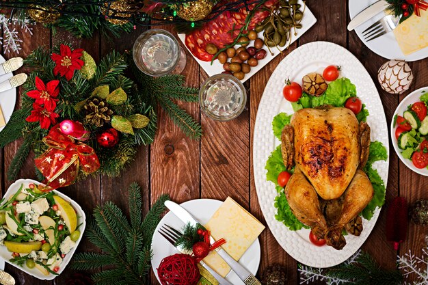 Mesa navideña servida con pavo, decorada con brillantes guirnaldas y velas.